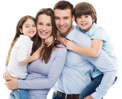 A young couple with two children, all of them smiling.